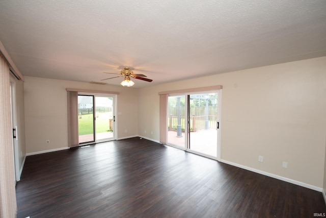 empty room with ceiling fan, dark hardwood / wood-style flooring, and a wealth of natural light