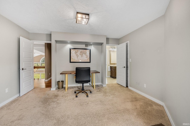 carpeted home office with a textured ceiling