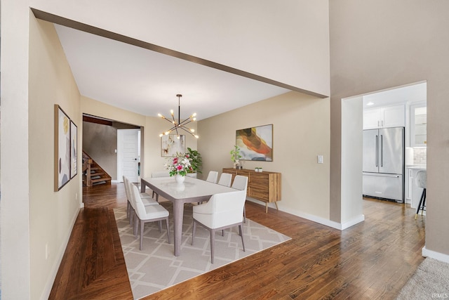 dining room with dark wood-type flooring and an inviting chandelier