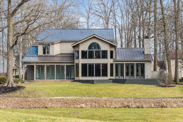 rear view of property with a sunroom and a lawn