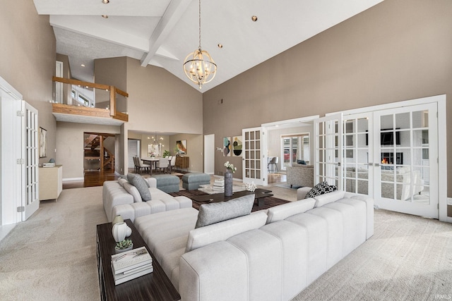 living room featuring beam ceiling, light colored carpet, french doors, and a chandelier