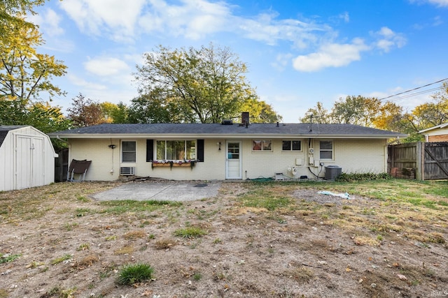 back of property with a storage shed, central AC unit, and a patio area