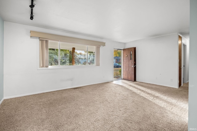 empty room with rail lighting and carpet floors