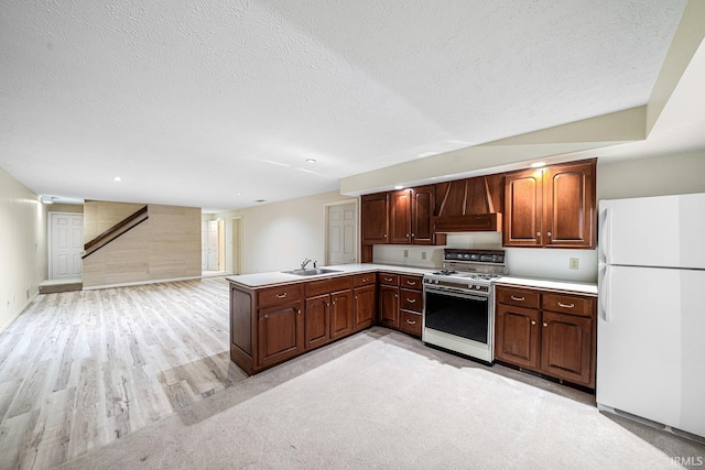 kitchen featuring sink, white appliances, a textured ceiling, custom exhaust hood, and kitchen peninsula