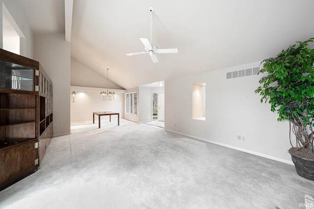 carpeted living room with ceiling fan with notable chandelier and high vaulted ceiling