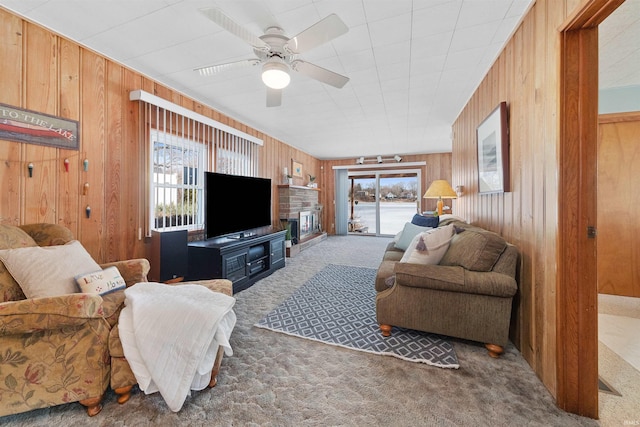 living room with plenty of natural light, wooden walls, and dark carpet