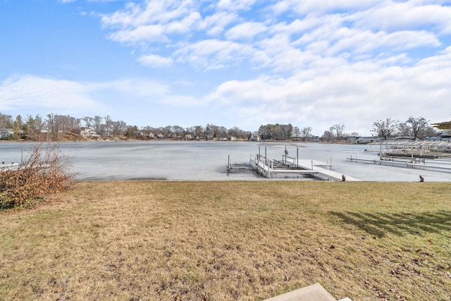 view of dock with a water view and a yard