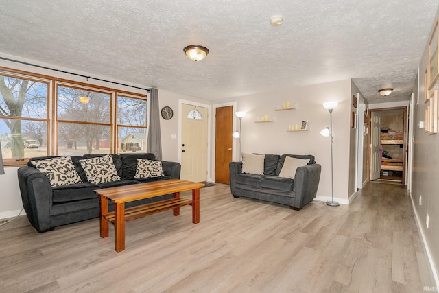 living room with a textured ceiling and light hardwood / wood-style flooring