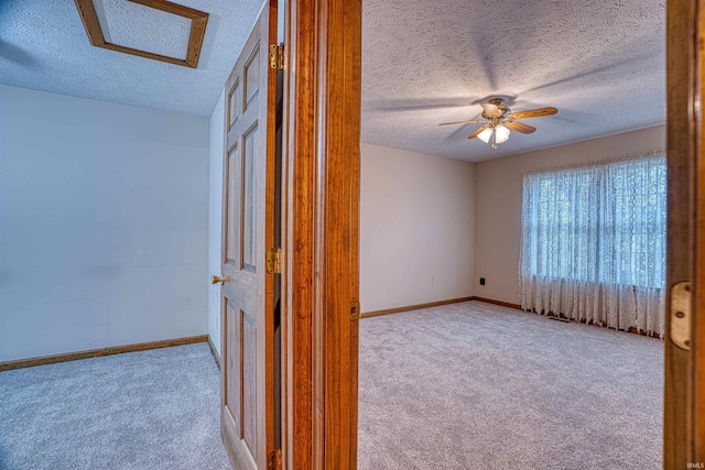 interior space featuring light carpet, ceiling fan, and a textured ceiling