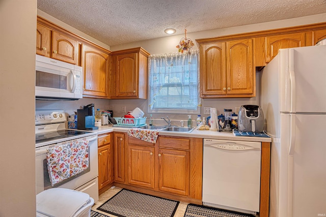 kitchen with sink, light tile patterned floors, a textured ceiling, and white appliances