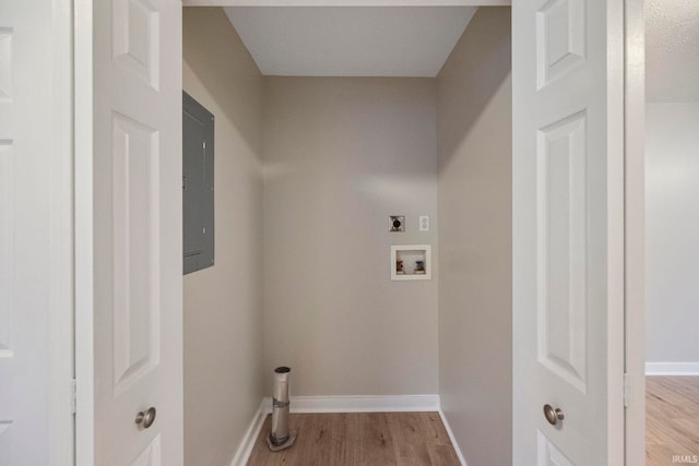 laundry room with hookup for a washing machine, hookup for an electric dryer, electric panel, and light hardwood / wood-style flooring