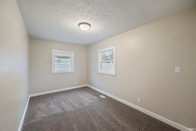 carpeted empty room with a textured ceiling