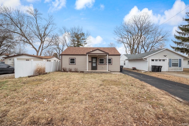 single story home featuring a garage, a front yard, and covered porch