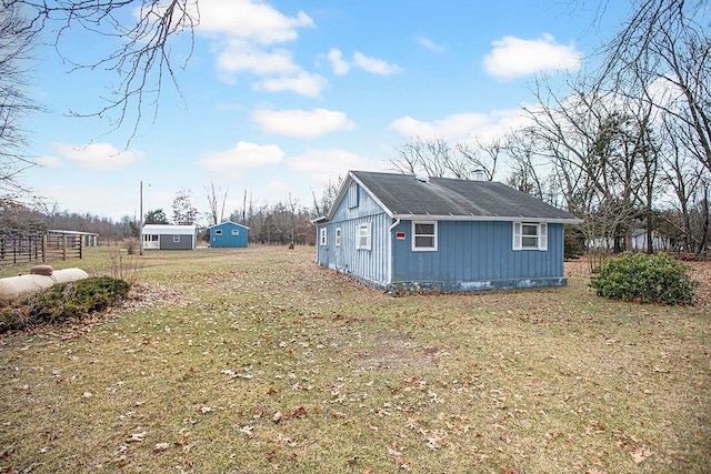 view of side of property with an outbuilding and a lawn