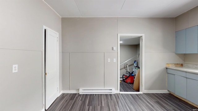 unfurnished dining area with dark wood-style flooring and a baseboard heating unit