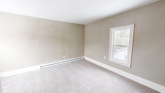 carpeted empty room with baseboards and a baseboard heating unit