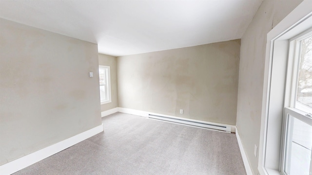 carpeted spare room featuring baseboards, a wealth of natural light, and a baseboard radiator