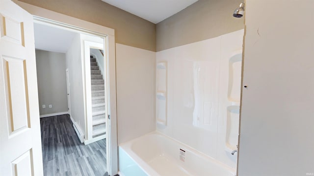 bathroom with shower / bathtub combination, baseboards, and wood finished floors