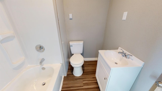 full bathroom featuring wood finished floors, baseboards, toilet, and vanity