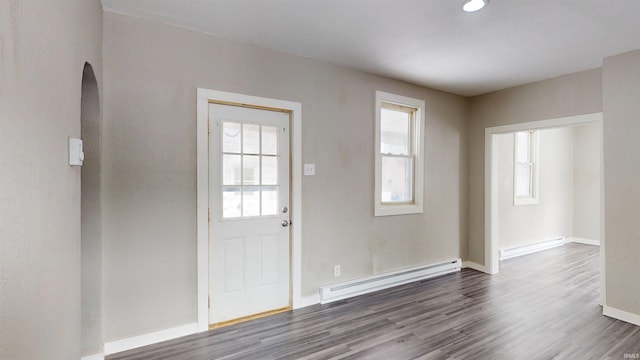 entryway with baseboard heating, a healthy amount of sunlight, and dark wood finished floors