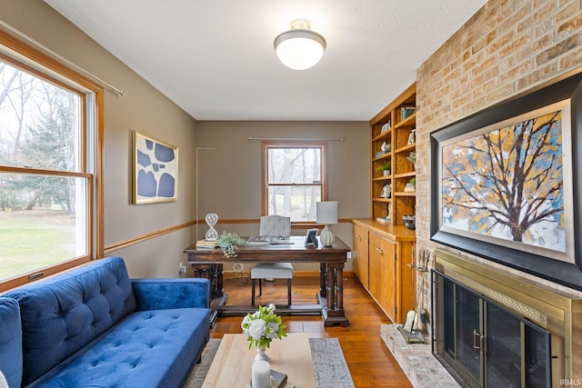 office featuring hardwood / wood-style floors and a fireplace