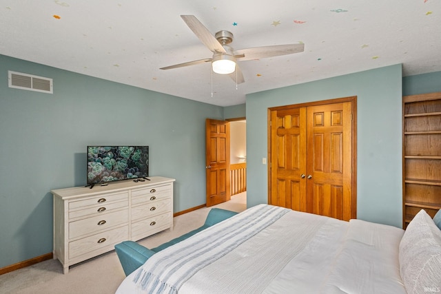 carpeted bedroom featuring a closet and ceiling fan