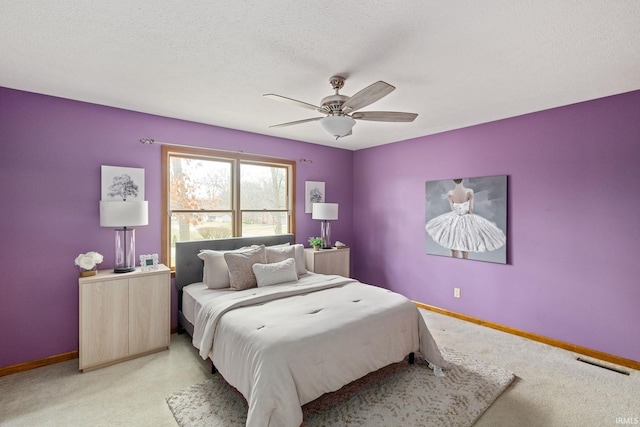 carpeted bedroom featuring ceiling fan and a textured ceiling