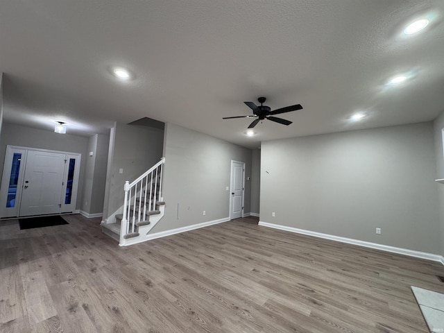 interior space with ceiling fan, light hardwood / wood-style floors, and a textured ceiling