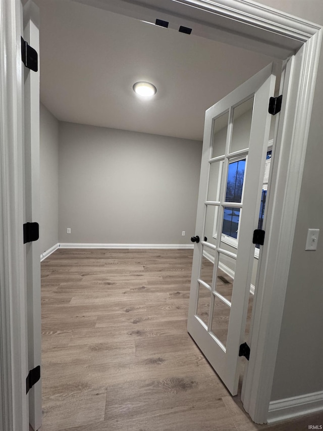 empty room with french doors and light hardwood / wood-style floors