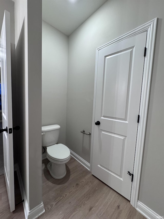 bathroom with toilet and hardwood / wood-style floors