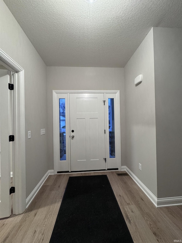 foyer featuring light hardwood / wood-style flooring and a textured ceiling