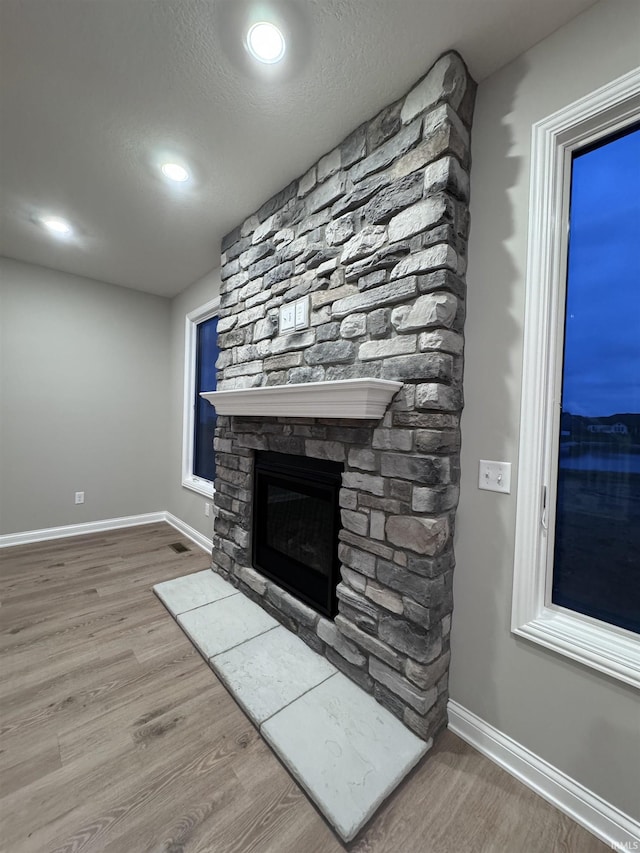 unfurnished living room featuring hardwood / wood-style floors, a textured ceiling, and a fireplace