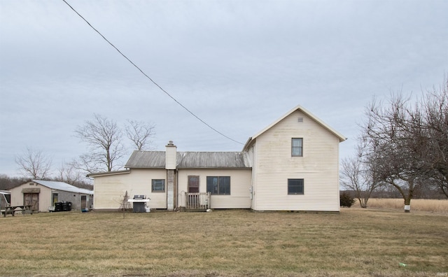 back of house featuring a storage shed and a lawn