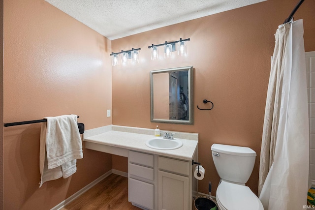 bathroom with hardwood / wood-style floors, vanity, a textured ceiling, toilet, and walk in shower