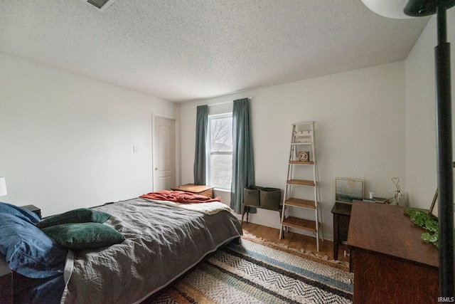 bedroom featuring wood-type flooring and a textured ceiling