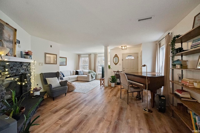 living room with wood-type flooring, a textured ceiling, and a fireplace