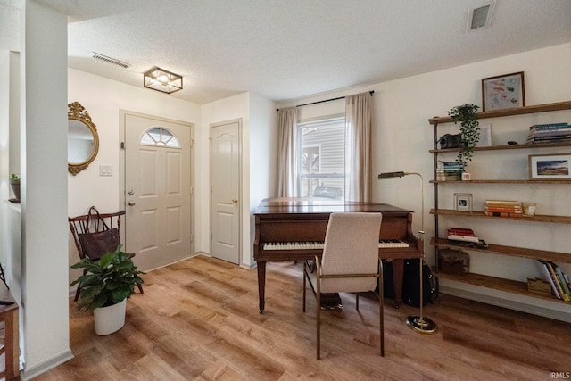 foyer featuring light hardwood / wood-style floors and a textured ceiling