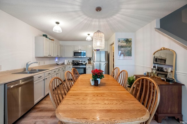 dining room with sink and light hardwood / wood-style flooring