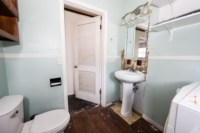 bathroom with sink, toilet, and washer / clothes dryer