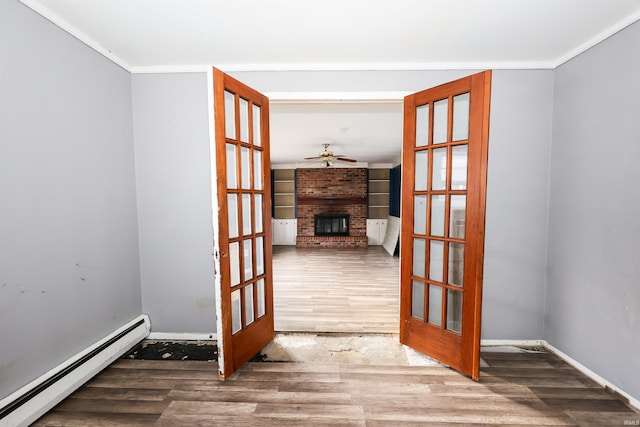 interior space featuring a baseboard heating unit, crown molding, hardwood / wood-style floors, and french doors