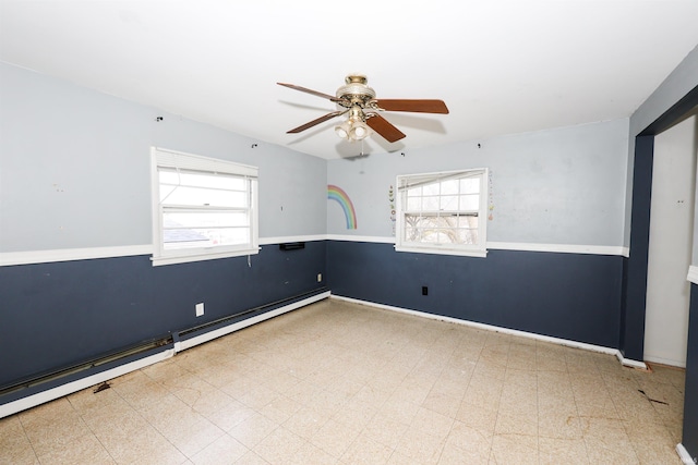 unfurnished room with a baseboard heating unit and ceiling fan