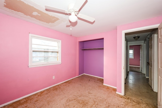 unfurnished bedroom with ceiling fan and a closet