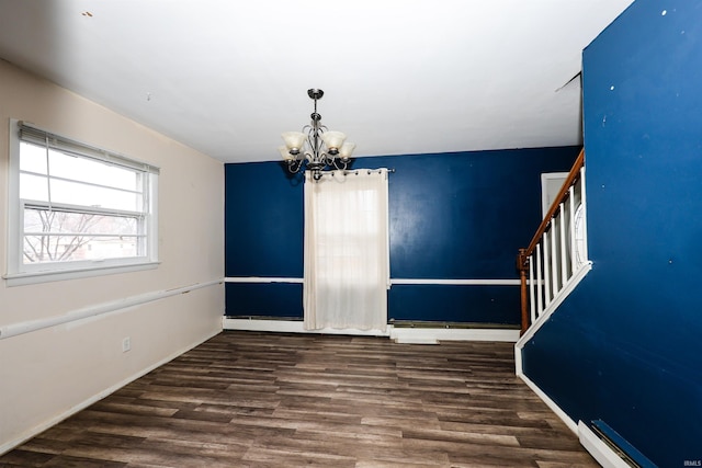 unfurnished dining area featuring dark hardwood / wood-style flooring, a notable chandelier, and baseboard heating