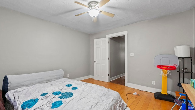 bedroom featuring hardwood / wood-style flooring, a textured ceiling, and ceiling fan