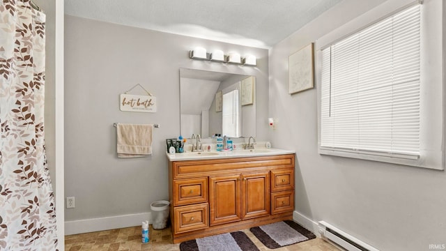 bathroom featuring baseboard heating, vanity, and a textured ceiling