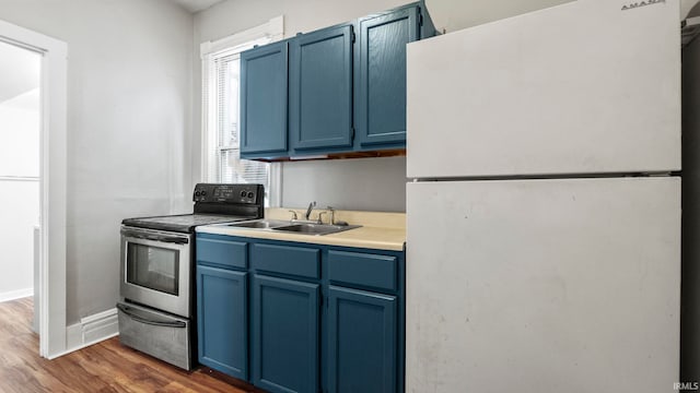 kitchen with white fridge, blue cabinetry, dark wood-type flooring, and stainless steel range with electric stovetop