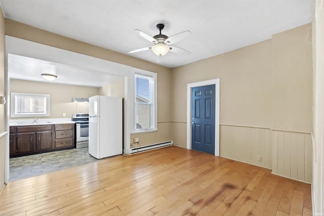 kitchen featuring light hardwood / wood-style flooring, white refrigerator, dark brown cabinetry, a baseboard radiator, and stainless steel range with electric cooktop