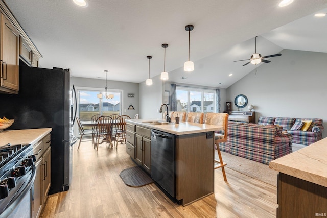 kitchen with sink, decorative light fixtures, a center island with sink, stainless steel range with gas stovetop, and dishwasher