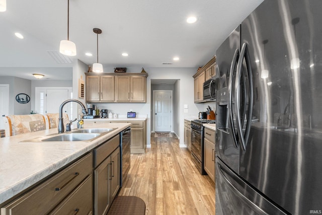 kitchen with sink, light hardwood / wood-style flooring, black appliances, and hanging light fixtures