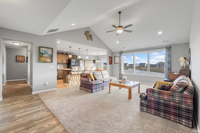 living room featuring ceiling fan, high vaulted ceiling, and light wood-type flooring